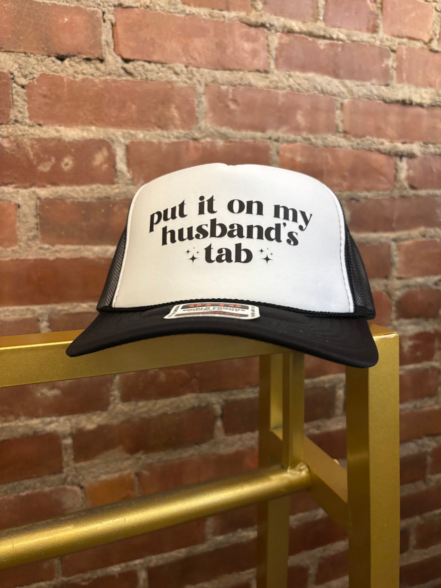 Put it on my husband's tab Trucker Hat